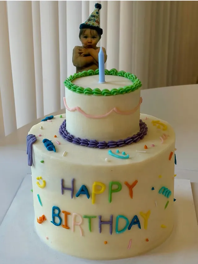 עוגת קומות לגיל שנה עם כיתוב צבעוני Happy Birthday ונר כחול